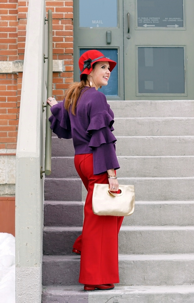 Winnipeg Style fashion stylist, Chicwish purple knit top with tiered sleeves, ThePeachBox roman numerial pink gold bangle, buckle silver bangle bracelet, Victoria Secret wide leg red pants, Danier leather gold clutch bag